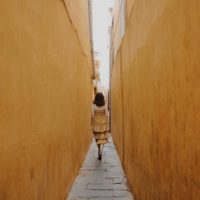 mulher de vestido amarelo a caminhar pelo caminho