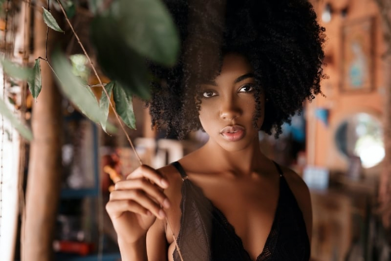 woman in black top standing near plant