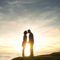 a man and a woman stand embracing