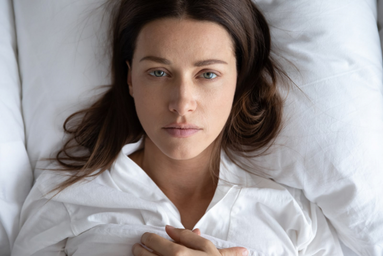 sad young woman laying in bed