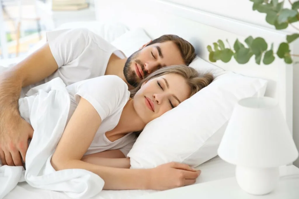 a cute couple sleeping together in bed
