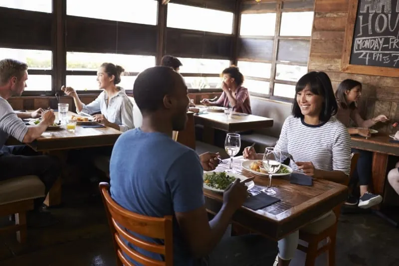 smiling woman and man eating at restaurant during daytime