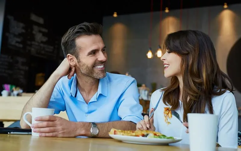 couple eating breakfast at a fast food/coffee shop having good conversation
