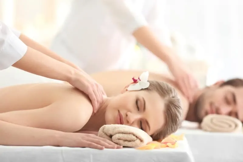 man and woman getting back massage at spa