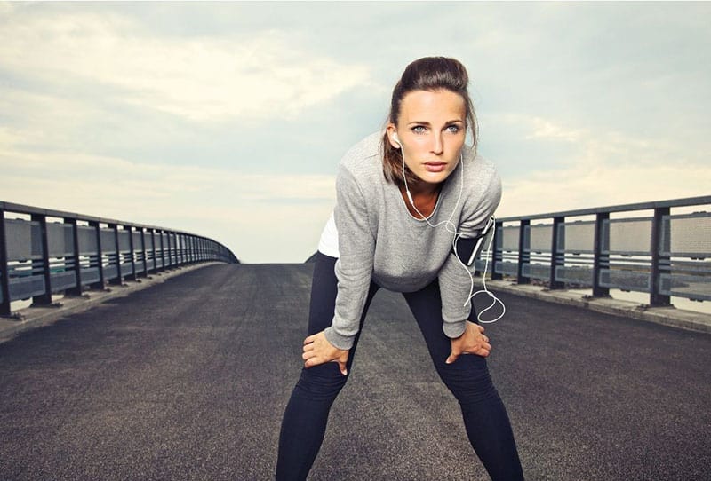 mujer decidida en la carretera descansando de hacer footing