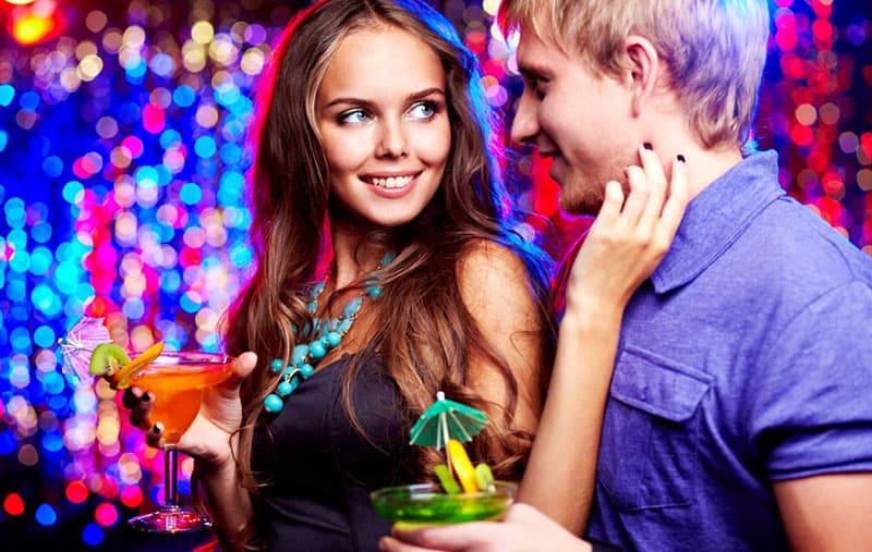 girl with a cocktail flirting with her boyfriend in a party