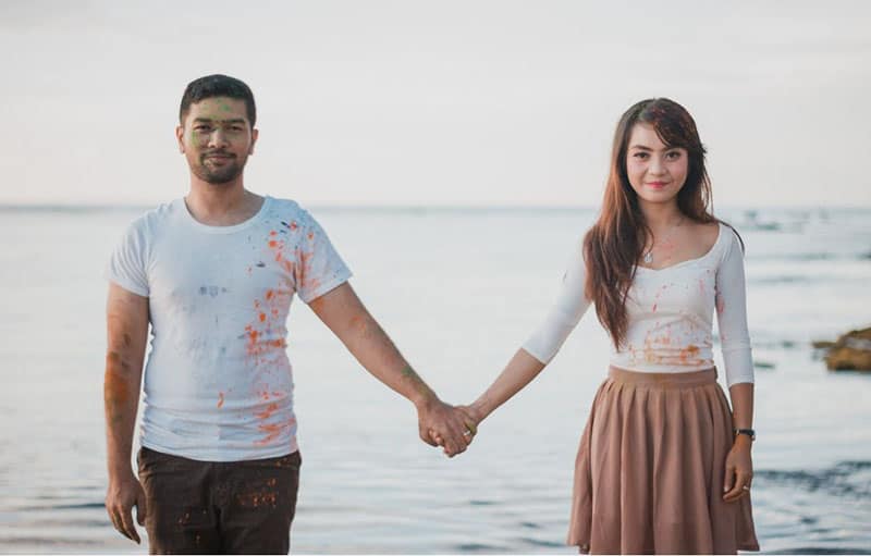 man and woman standing beside the sea holding hands