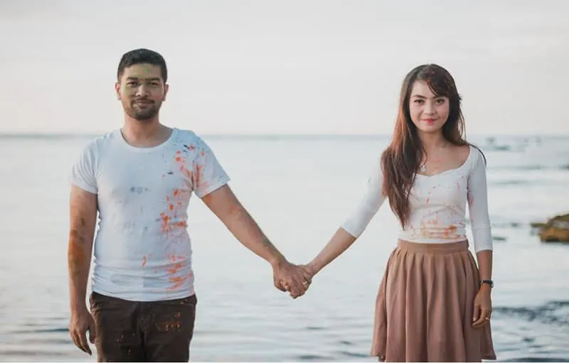 man and woman standing beside the sea holding hands