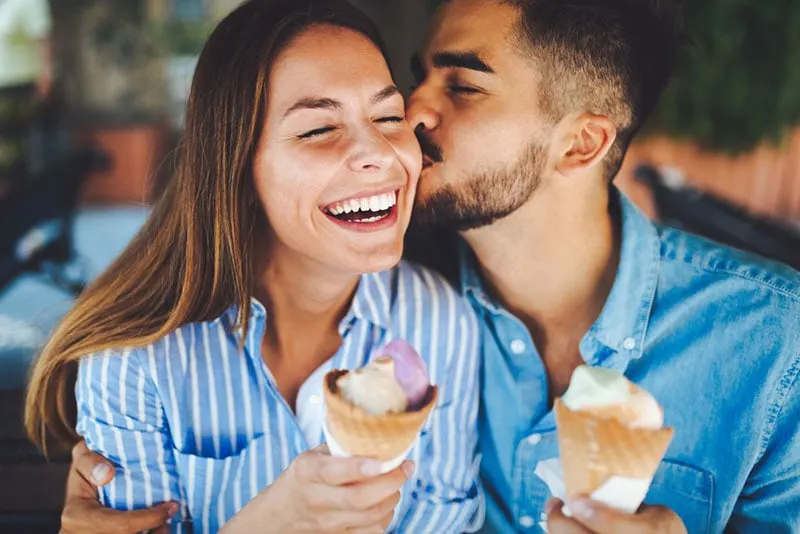man kissing woman on the cheek