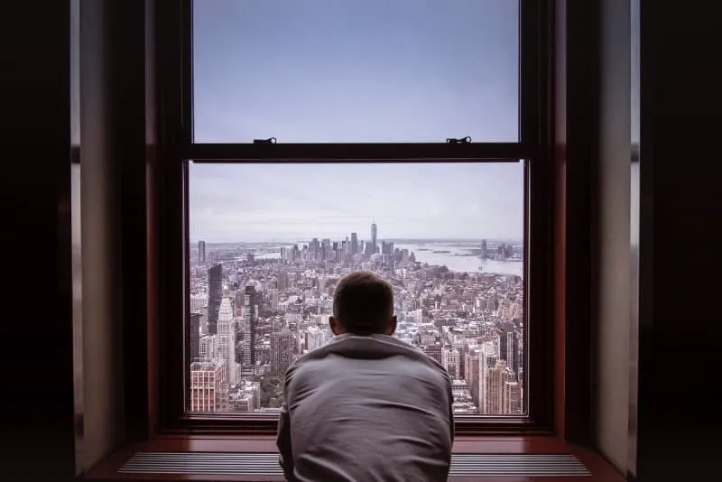 man in gray shirt looking at city buildings