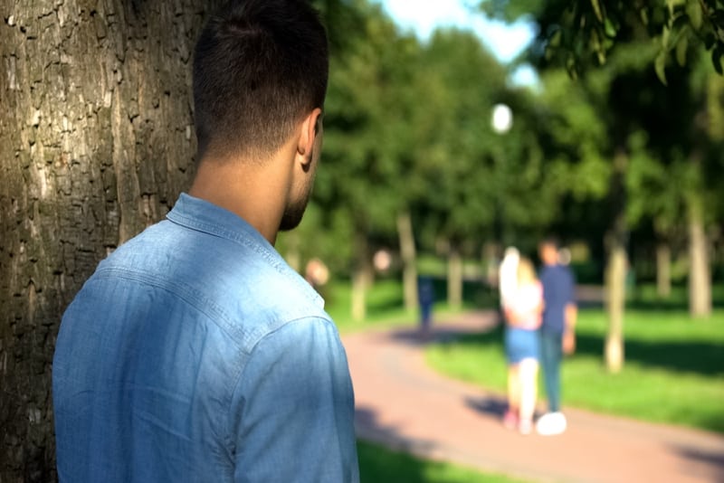 man in blue shirt looking at couple outdoor