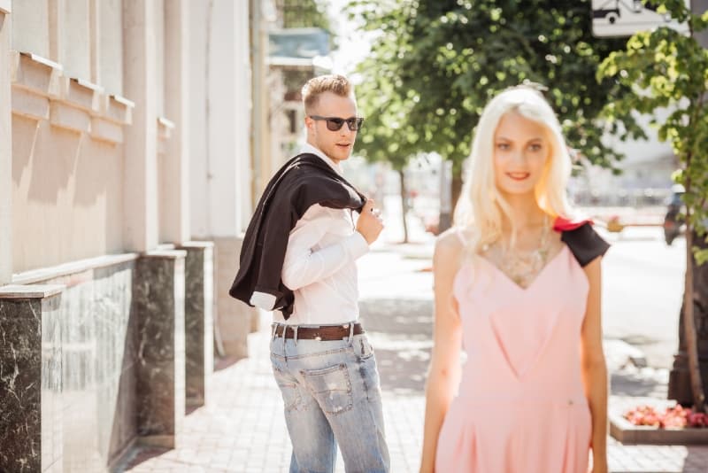 man looking at woman while standing in the street