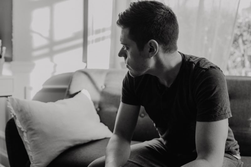 man in black t-shirt sitting on sofa