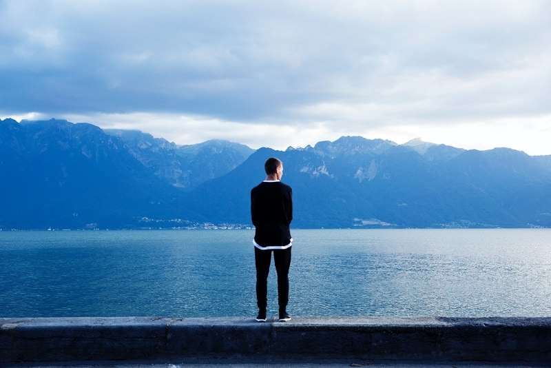 man in black sweatshirt standing near water