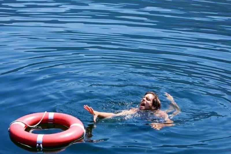 man struggling to get a lifebuoy to be saved from drowning