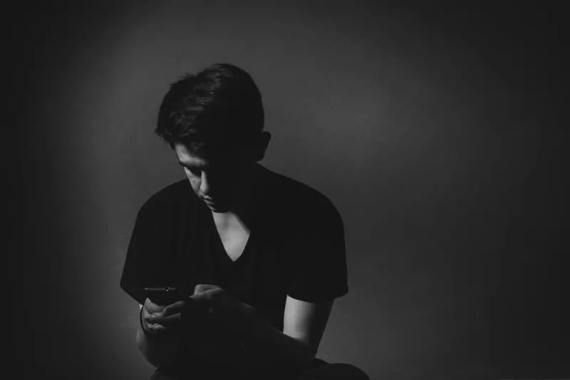 man using his phone in dark room