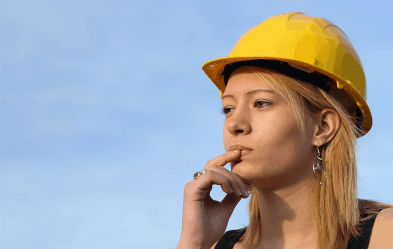 visionary young woman wearing a hard hat while thinking