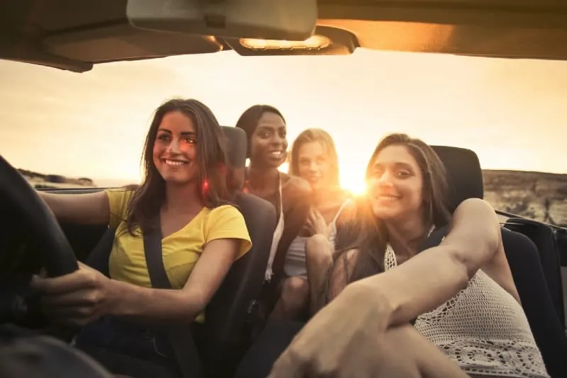 woman driving car with her friends