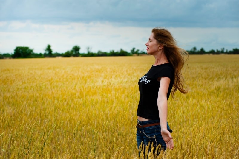 mulher de camisa preta parada num campo