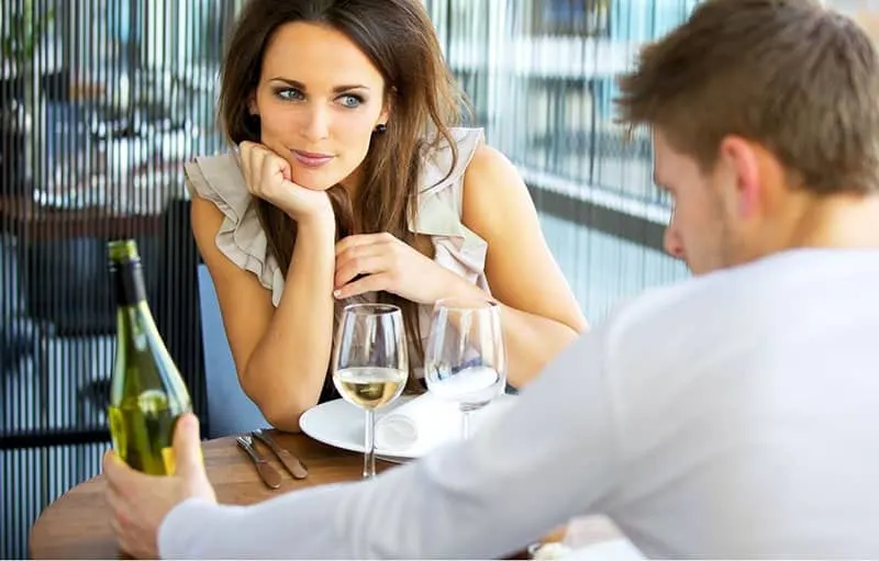 woman in love listening to the man talking about the wine in their table