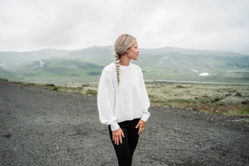 woman in white top standing outdoor looking at mountain