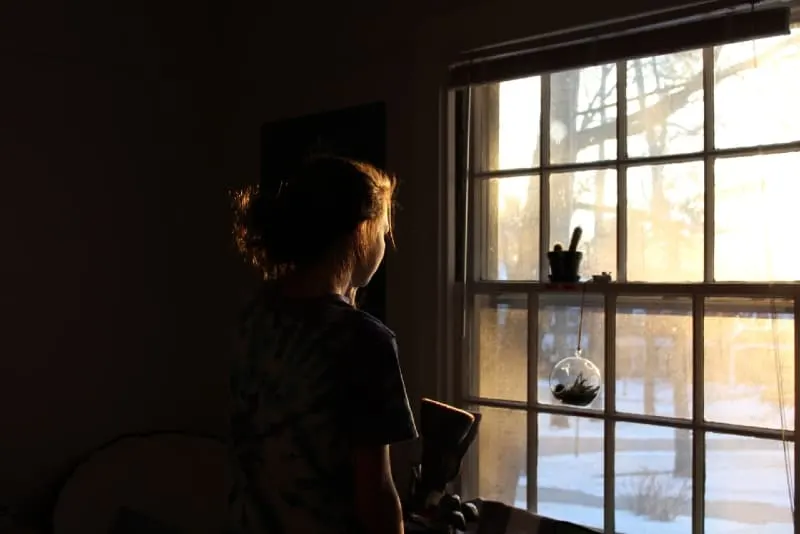 woman looking through window during daytime