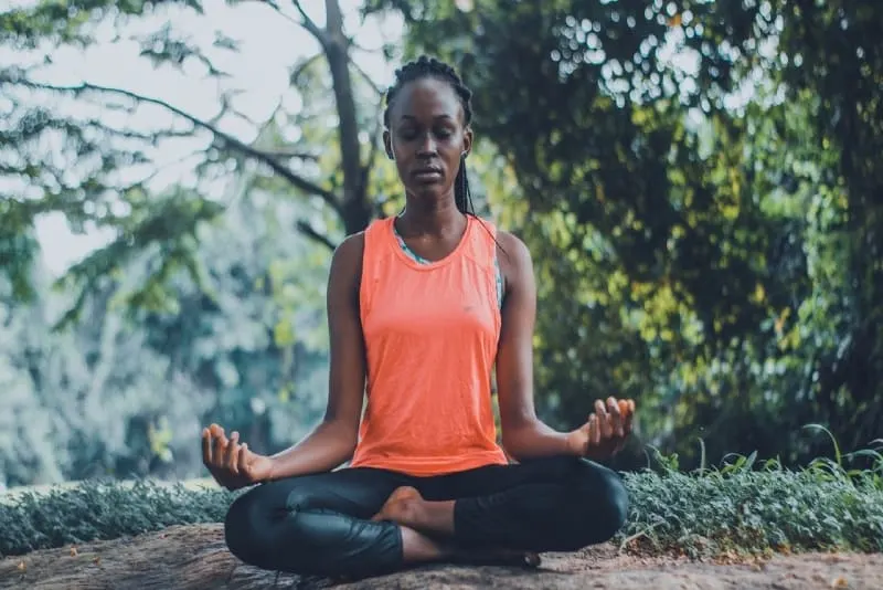 woman meditating while sitting on ground