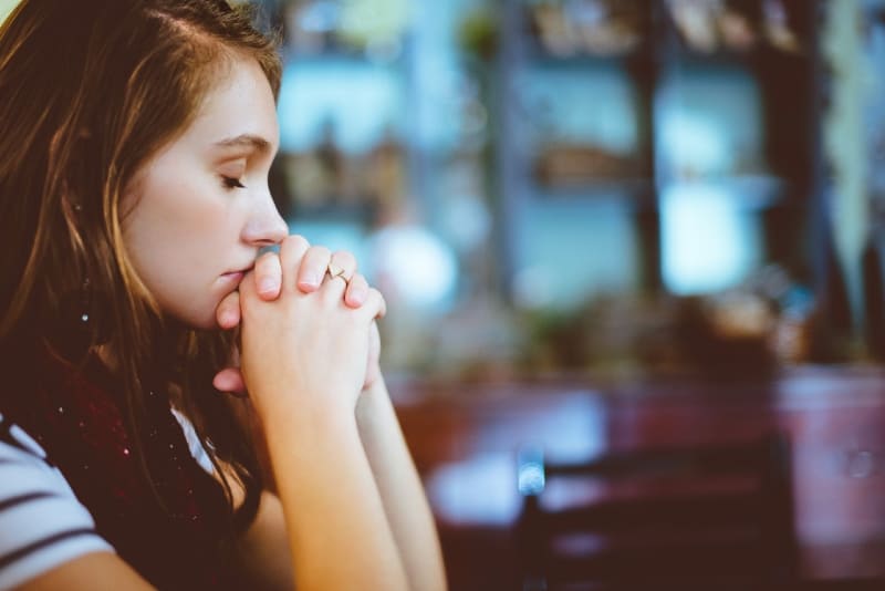 woman with eyes closed praying