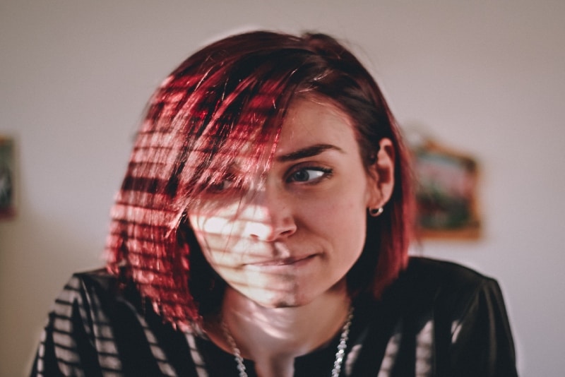 donna con capelli rossi seduta al chiuso