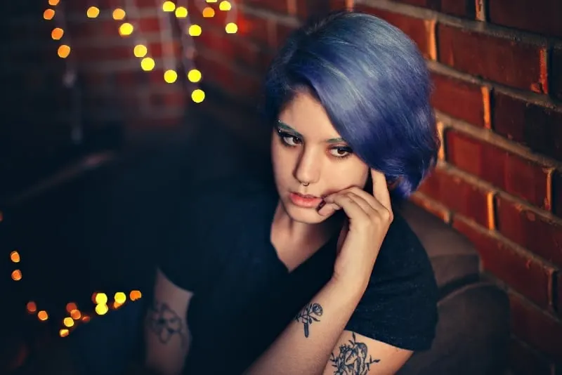 woman with blue hair sitting on armchair
