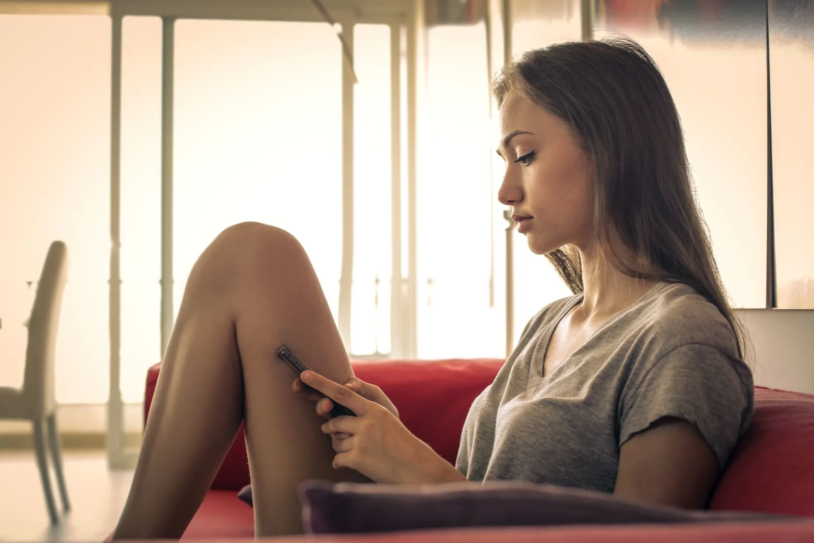 woman sitting on the couch holding phone