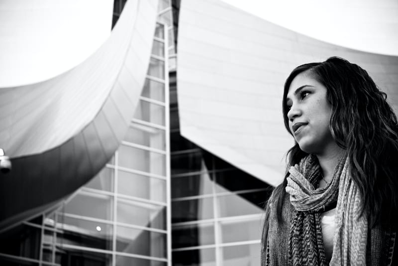 woman with scarf standing near building