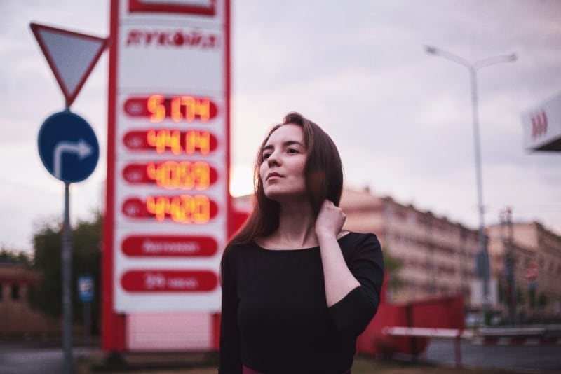 woman in black top standing near gasoline station