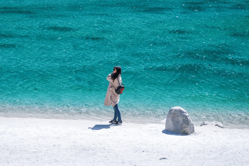 mujer con mochila cerca del agua