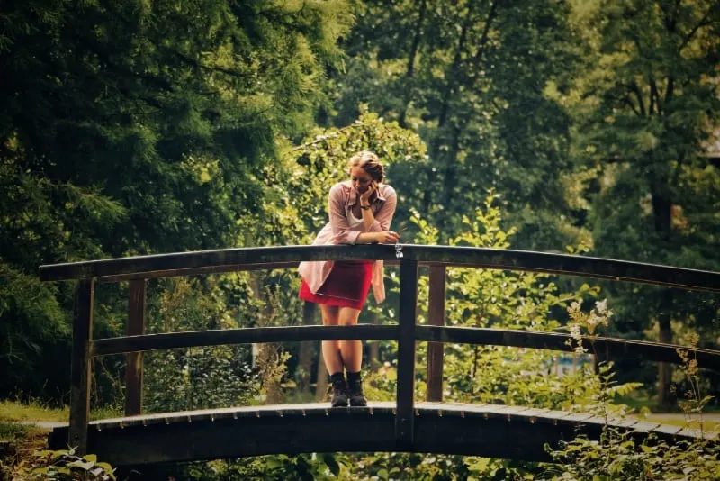 woman standing on bridge near trees