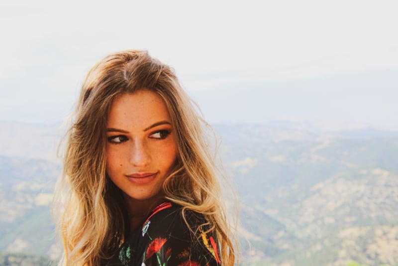 woman in floral top standing on hill