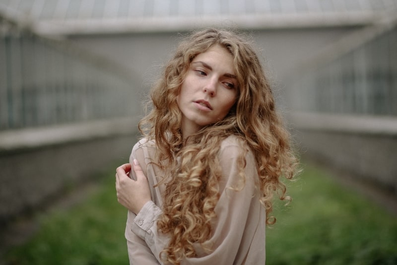 donna con capelli lunghi e ricci in piedi all'aperto