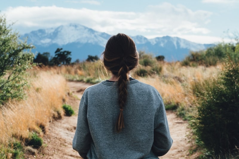 mujer caminando por el sendero durante el día