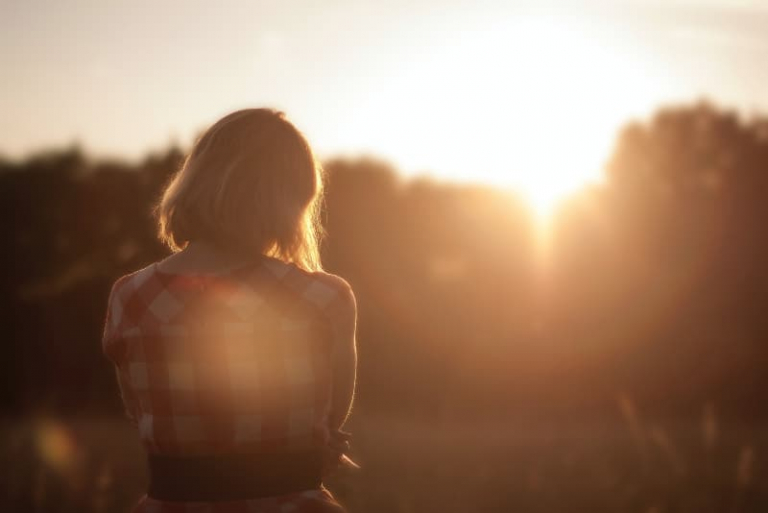 mujer de pie al aire libre durante la salida del sol