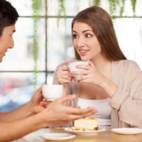 man talking to woman while having coffee