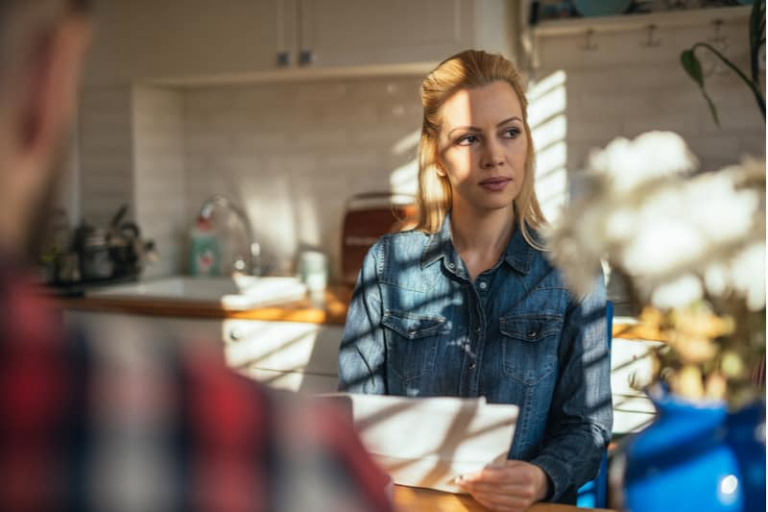 attractive woman thinking about options sitting infront of a man inside home