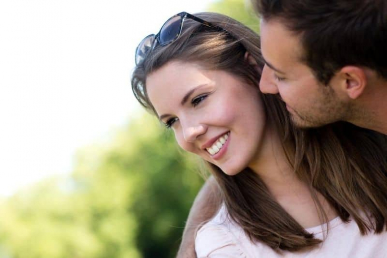 beautiful couple man looking and trying to kiss his wife smiling outdoors
