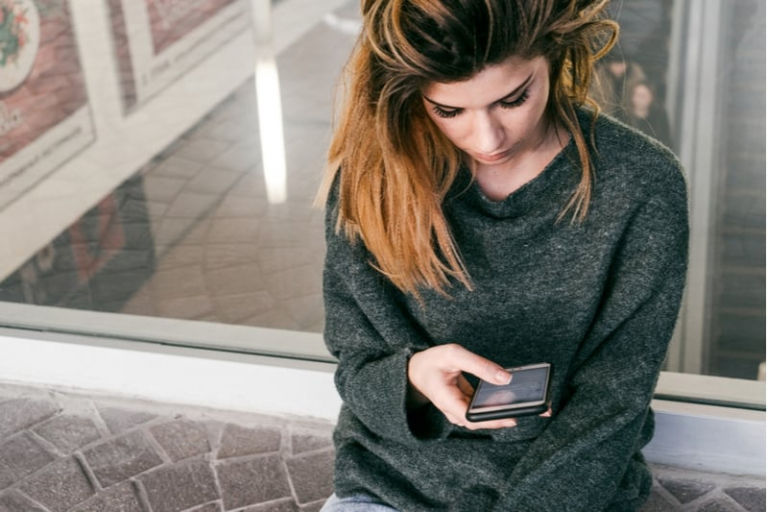 woman checking on the smartphone texting with black mobile
