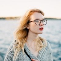 woman with eyeglasses standing near water