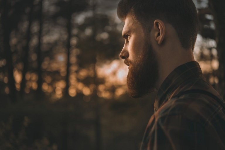 confident bearded man in forest