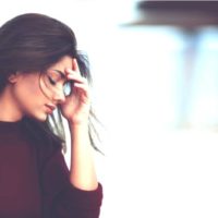 pensive sad woman with hand on head