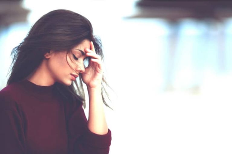 pensive sad woman with hand on head