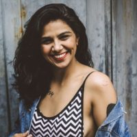 smiling woman in printed top standing near wall