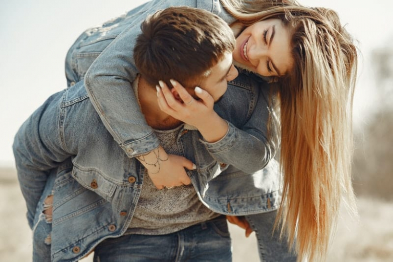 sweet couple piggyback wearing denim jackets