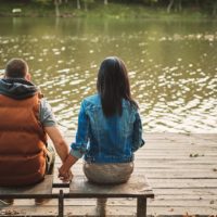 couple holding hands sitting on the bench